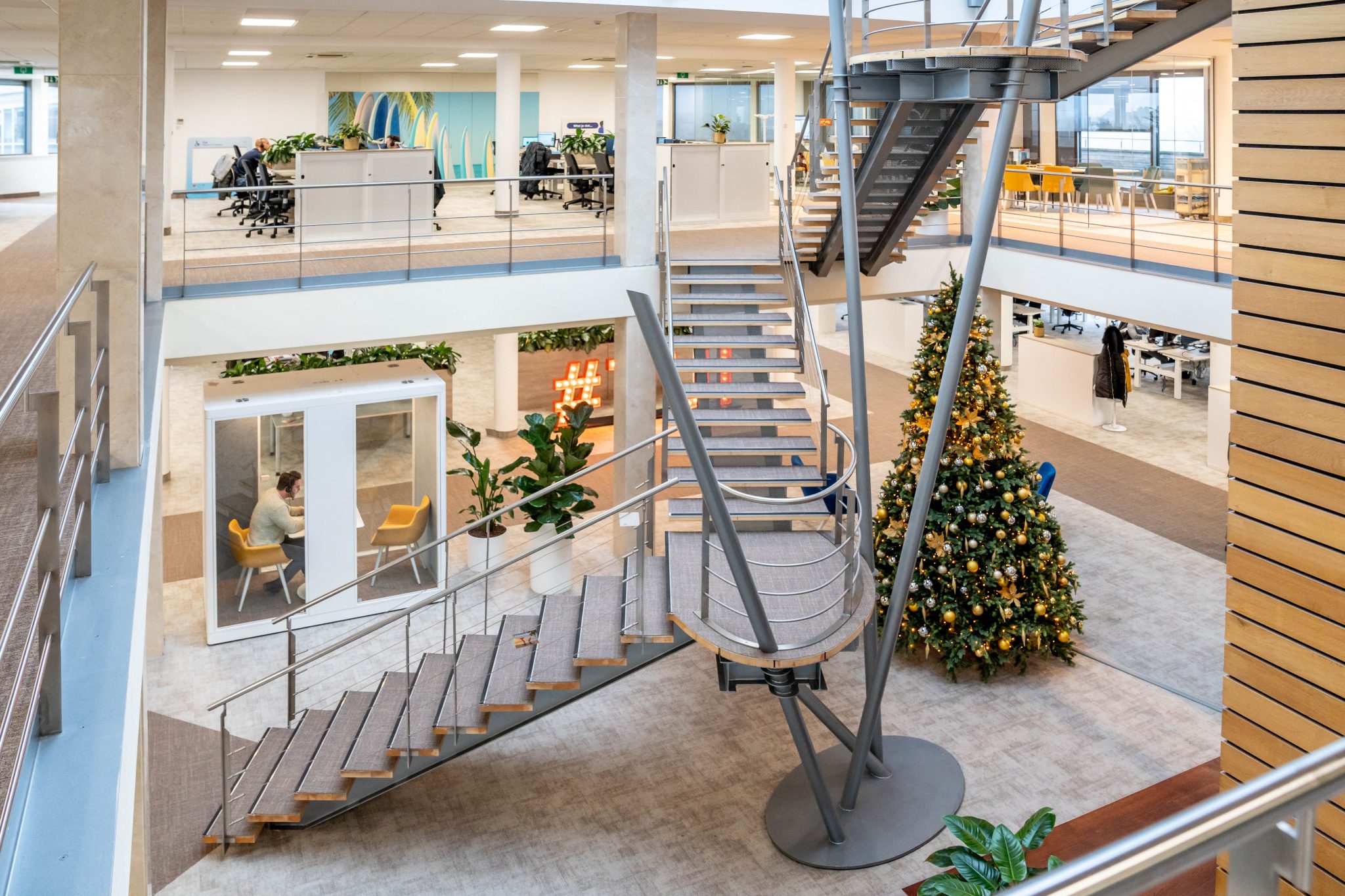 medewerker Green at the Office versiert kerstboom - Collaborateur Green at the Office décore un sapin de Noël